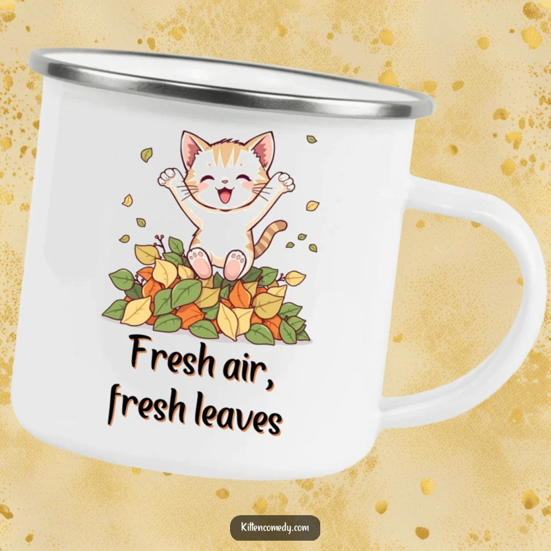 Funny kitten camping mug illustrating a cat joyfully leaping into autumn leaves, ideal for outdoor enthusiasts who appreciate humor.